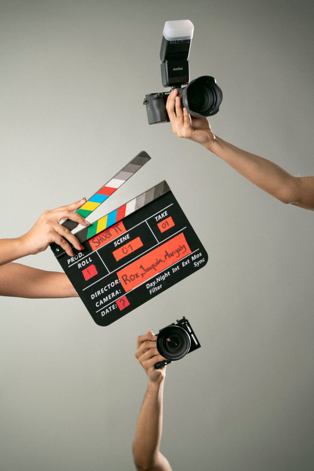 Claqueta con nombres de los fundadores y dos cámaras sujetadas por el staff.